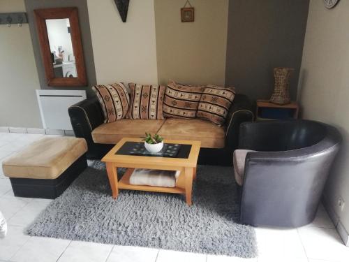 a living room with a couch and a coffee table at LE GITE DE LA MAISON ROUGE in Anctoville