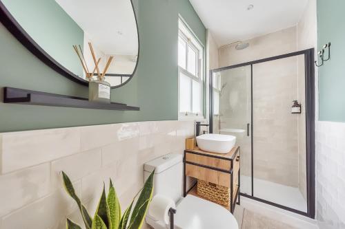 a bathroom with a toilet and a sink and a mirror at The Little Domus - modern YORK home with HOT TUB in York