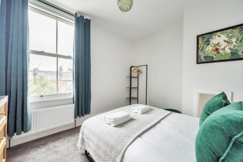 a white bedroom with a bed and a window at The Little Domus - modern YORK home with HOT TUB in York