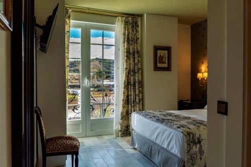 a bedroom with a bed and a window with a view at Palacete de la Ochava in Valdilecha