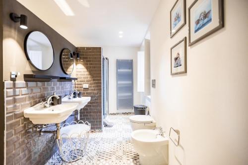 a bathroom with two sinks and two toilets at Casa Paola, eleganza nel cuore di Suvereto in Suvereto
