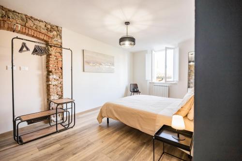 a bedroom with a bed and a brick wall at Casa Paola, eleganza nel cuore di Suvereto in Suvereto