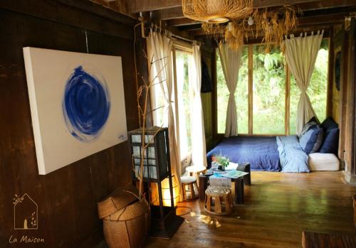 a living room with a bed and a large window at Sa Moc - La Maison House & Bungalow in Sa Pa