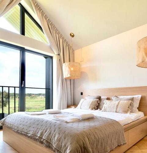 a bedroom with a large bed with a large window at Modern Villa By The Sea in Palanga