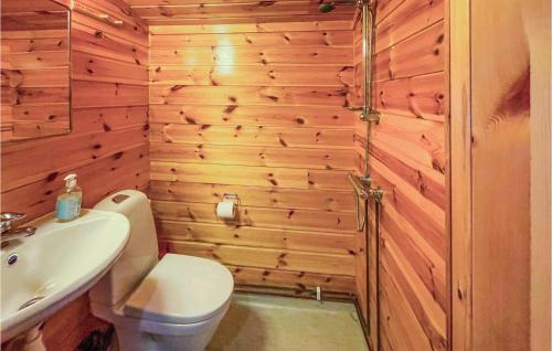 uma casa de banho com paredes de madeira, um WC e um lavatório. em Beautiful Home In Grue Finnskog With Kitchen em Svullrya
