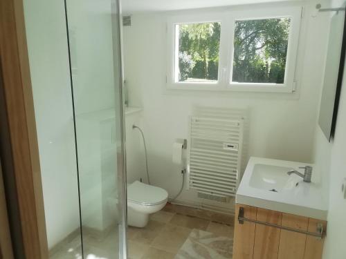 a bathroom with a toilet and a sink and a window at Logement avec 2 chambres pour 5 personnes maxi 