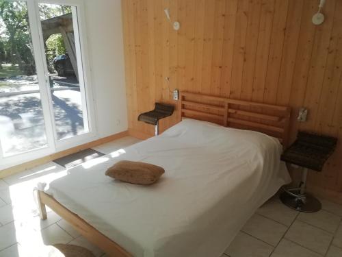 a bedroom with a white bed and a window at Logement avec 2 chambres pour 5 personnes maxi 