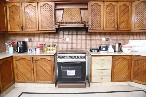 a kitchen with wooden cabinets and a stove at Waypoint Hotel in Karachi