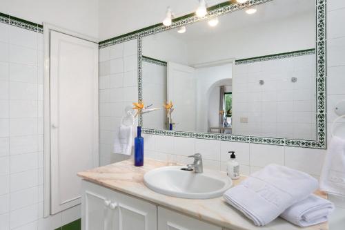 a white bathroom with a sink and a mirror at La Villa La Palma- 1 dormitorio B in Los Barros