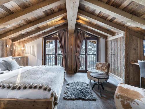 une chambre avec un lit, une chaise et des fenêtres dans l'établissement Luxueux appartement 4 chambres avec hammam, proche centre et pistes de Val d'Isère - FR-1-567-42, à Val dʼIsère