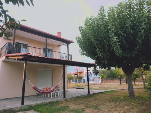 a house with a hammock on the side of it at Kerasies Home in Karianí