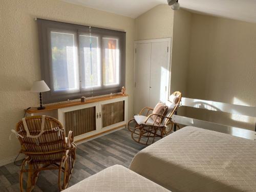 a bedroom with a bed and a window and chairs at Casa Tere Panticosa in Panticosa