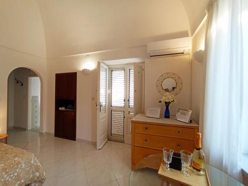 a bedroom with a bed and a dresser with a mirror at L'Archetto romantic suite in the center of Anacapri in Anacapri