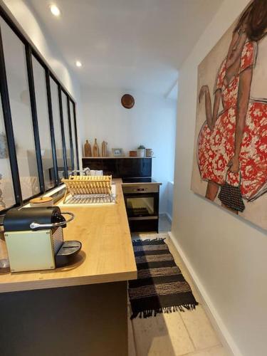 une chambre avec une table et un tableau sur le mur dans l'établissement Chez Laurette - Charming apartment in historic village near Versailles, à Marly-le-Roi
