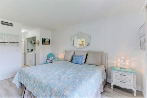 una camera con letto, specchio e tavolo di Resort Style Condo by the Beach with Heated Pool at Runaway Bay a Bradenton Beach
