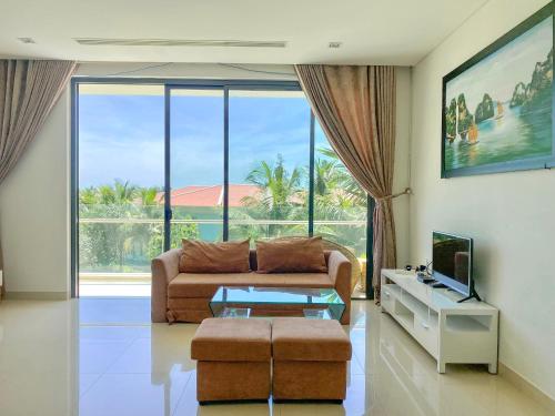 uma sala de estar com um sofá e uma televisão em Danang Amazing Ocean Villas em Da Nang