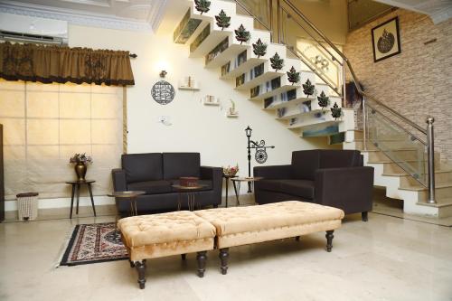 a living room with a staircase and a bench at Waypoint Hotel in Karachi