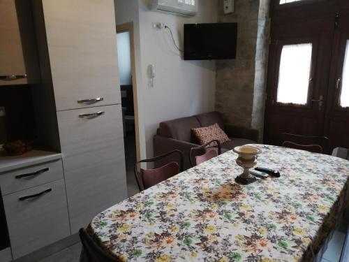 una cocina con una mesa con un patrón de flores. en A Casa Grelletto Gubbio, en Gubbio