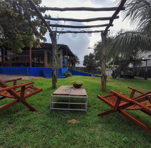 a picnic area with two benches and a table at Suíte quádrupla Odoyá Beach in Conde