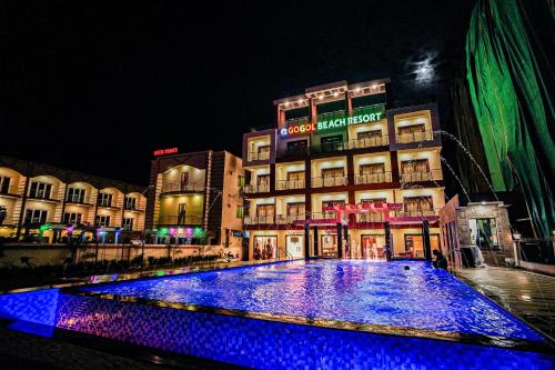 a large pool of blue lights in front of a building at Gogol Beach Resort !! Beach 1 Minute !! in Mandarmoni
