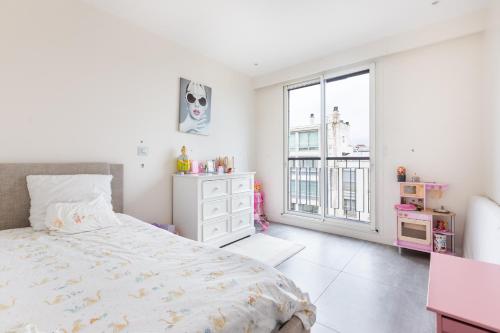 une chambre blanche avec un lit et une fenêtre dans l'établissement Luxury Eiffel Tower Paris, à Paris