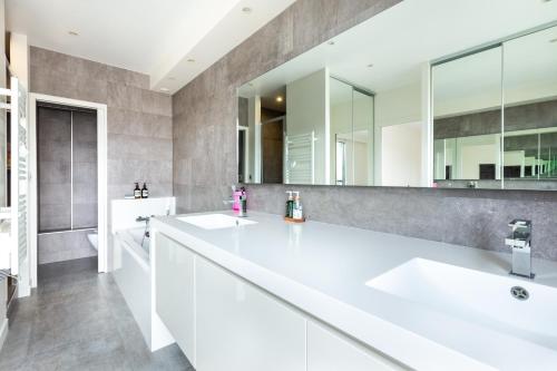 une salle de bain avec deux lavabos et un grand miroir dans l'établissement Luxury Eiffel Tower Paris, à Paris