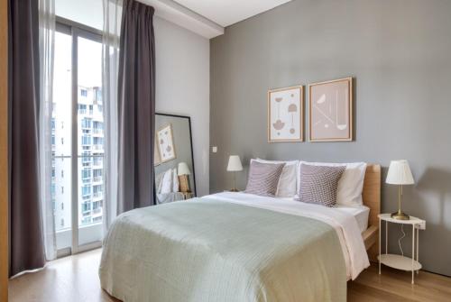 シンガポールにあるSpectacular 1BR Apartment in Singapore!の白いベッドルーム(大型ベッド1台、大きな窓付)