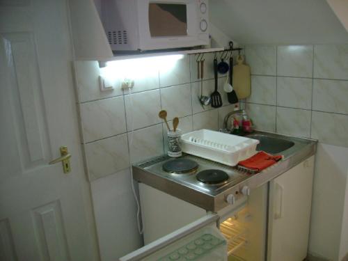 a small kitchen with a sink and a microwave at Álmos Apartman in Siófok