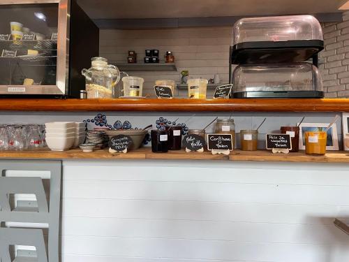 un comptoir de cuisine avec une étagère sur laquelle sont posés des objets dans l'établissement Logis Hôtel Restaurant Le Castel Fleuri, à Saint-Jean-en-Royans