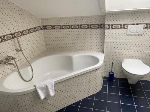uma casa de banho com banheira e WC em Gemütliches Zimmer mit großem Bad em Recklinghausen