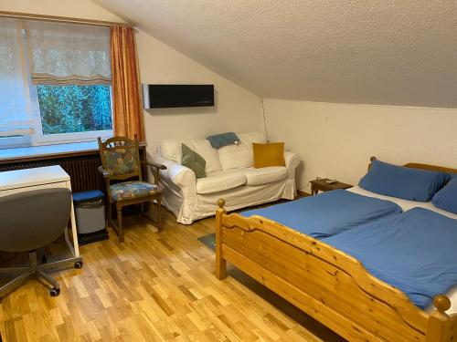 um quarto com uma cama, um sofá e uma cadeira em Gemütliches Zimmer mit großem Bad em Recklinghausen