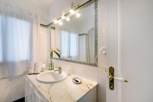 a white bathroom with a sink and a mirror at La Villa La Palma- 2 dormitorios B in Los Barros