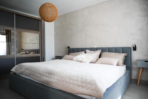 a bedroom with a large white bed with pink pillows at Sunshinewilla com - amazing sea view - private pool - 4 bedrooms - 3 bathrooms - workout in Kaštelir
