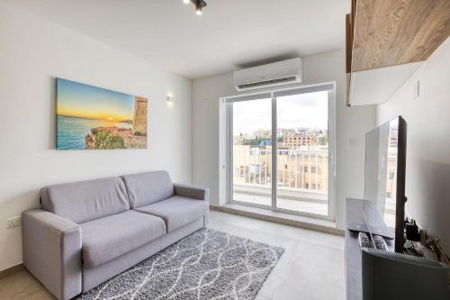 a living room with a couch and a large window at GZIRA Suite 14-Hosted by Sweetstay in Il-Gżira