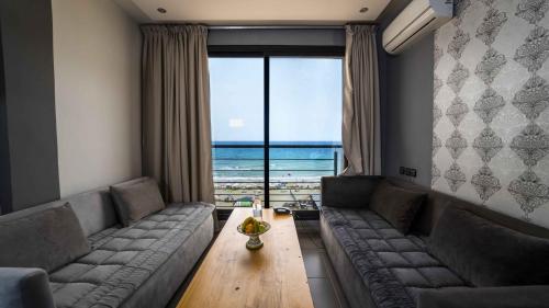 a living room with couches and a table and a view of the ocean at ALYA SAPHIR in Saidia 