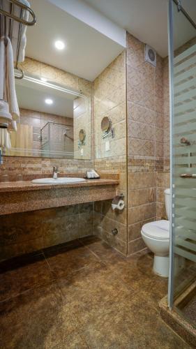 a bathroom with a sink and a toilet and a mirror at SeaVille Beach Hotel by Elite Hotels & Resorts in Ain Sokhna