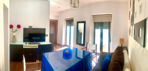 sala de estar con mesa azul y TV en Alcalá zona Centro, en Alcalá la Real