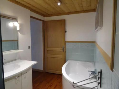 a bathroom with a white tub and a sink at La Chaumière in Les Contamines-Montjoie