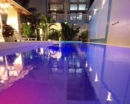 a swimming pool with blue and purple lighting in a building at Morona Flats & Pool - 70 m2 in Iquitos