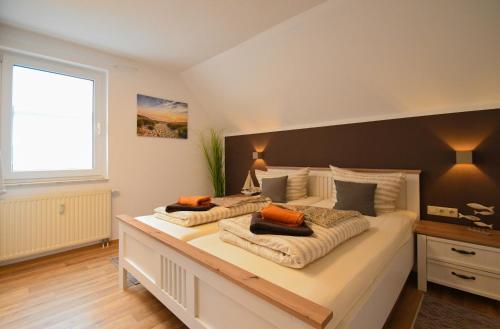 a bedroom with a large bed with two pillows on it at Ferienwohnung Weitblick mit Logia in Lobbe