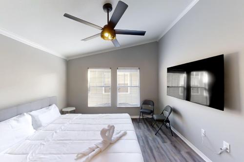 a bedroom with a white bed with a ceiling fan at Willow Haven in Tampa