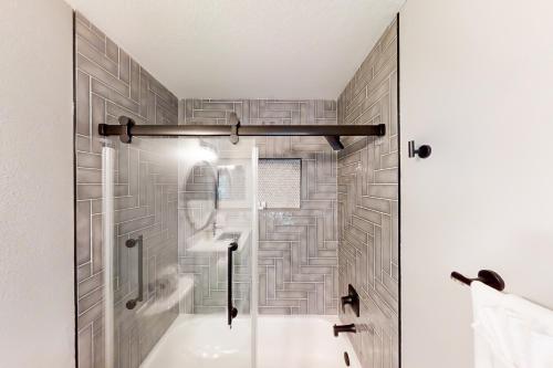 a bathroom with a shower with a tile wall at Willow Haven in Tampa