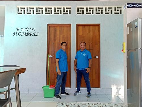 two men standing in front of two doors at Morona Flats & Pool - 70 m2 in Iquitos