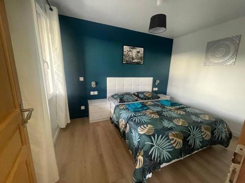 - une chambre avec un lit et un mur bleu dans l'établissement L8 - Villiers-le-Bel proche ROISSY & PARIS, à Villiers-le-Bel