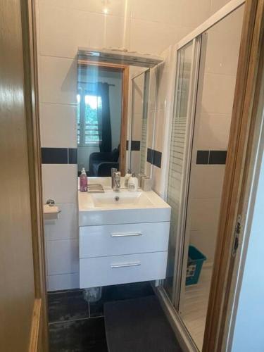 une salle de bain avec un lavabo blanc et un miroir dans l'établissement L8 - Villiers-le-Bel proche ROISSY & PARIS, à Villiers-le-Bel