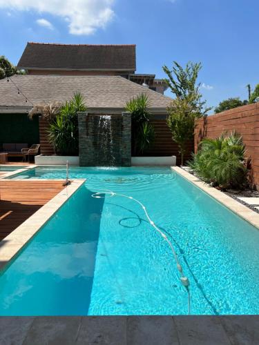 a swimming pool with a hose in front of a house at GrandCraftsman style home with pool and hot tub/ center to all of New Orleans in New Orleans