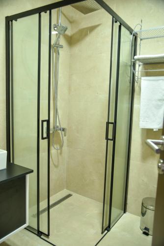 a shower with a glass door in a bathroom at Apartmani COLOSSEUM in Bratunac