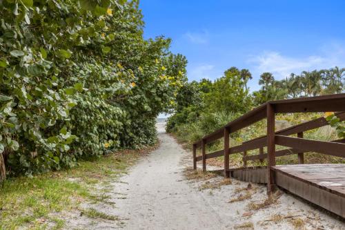 a bridge over a dirt road next to trees at Enjoy the Siesta Key Beach Life to the fullest! Beach AND Pool Access in Siesta Key