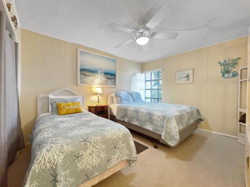 a bedroom with two beds and a ceiling fan at Siesta Beach Condo Rental with direct beach and pool access in Siesta Key