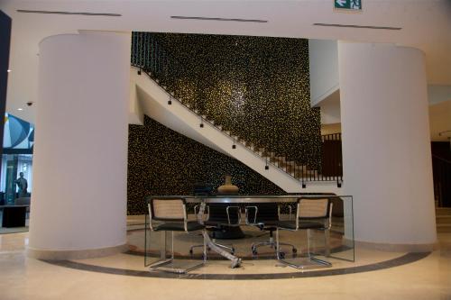a table and chairs in a room with a staircase at Hotel Continental Horizonte in Luanda